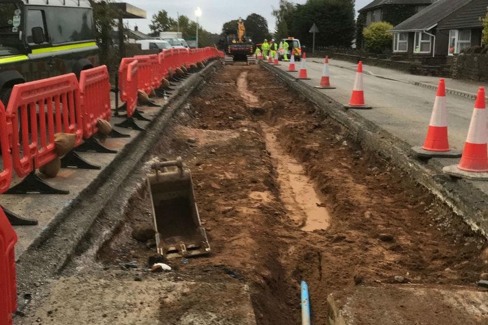 Roadworks trench on the A66 with safety barriers and site workers.