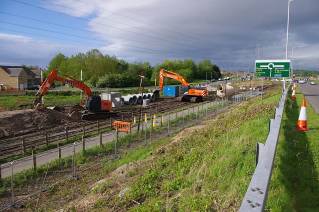 Drainage works beside the Heysham to M6 link road, with excavators and concrete pipes on site.